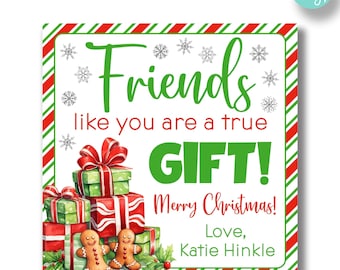 May include: A white card with red and green stripes around the border. The card has a Christmas-themed illustration of presents, gingerbread people, and snowflakes. The text on the card reads "Friends like you are a true GIFT! Merry Christmas! Love, Katie Hinkle".