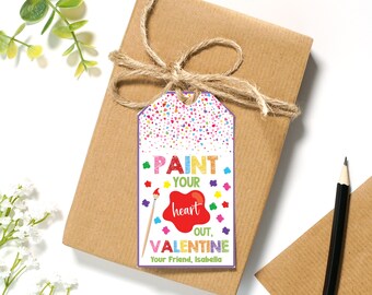 Puede incluir: Una etiqueta de regalo colorida para el Día de San Valentín con un pincel y un corazón rojo. El texto dice "Pinta tu corazón, Valentín. Tu amigo, Isabella."