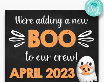 Op de afbeelding: Een zwart schoolbord met oranje en witte tekst die een nieuwe "BOO" voor de crew in april 2023 aankondigt. Een witte geest met een vriendelijk gezicht houdt een jack-o-lantern vast.