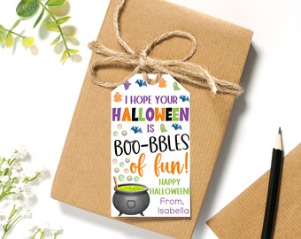 May include: A white gift tag with a black cauldron, green bubbling liquid, and bats. The text reads "I hope your Halloween is boo-bbles of fun! Happy Halloween! From, Isabella."