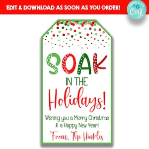 May include: A white gift tag with a green border and festive text. The words "SOAK IN THE Holidays!" are in red and green. The tag wishes a Merry Christmas and Happy New Year, signed "From, The Hinkles."