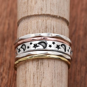 Peut inclure: Un ensemble de quatre bagues empilables avec un motif de lune et d'étoile. Les bagues sont en argent, or et cuivre.