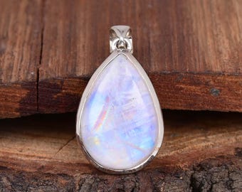May include: A teardrop-shaped pendant with a silver setting and a white moonstone gemstone. The moonstone has a blue iridescent sheen.