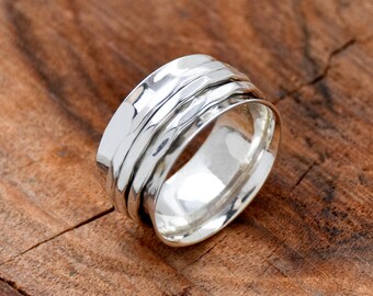 May include: A silver spinning ring with a hammered finish. The ring is made of multiple bands that spin freely around each other.