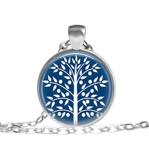 May include: A silver chain necklace with a round pendant featuring a white tree of life design on a dark blue background.