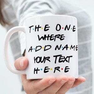 May include: White ceramic mug with a black design that says "The One Where ADD NAME YOUR TEXT HERE" with colourful dots between the words.