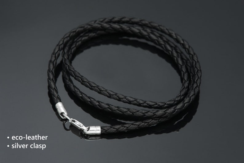 May include: A black braided leather cord necklace with a silver clasp.
