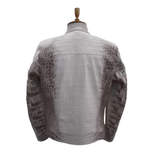 Puede incluir: Chaqueta de cuero texturizado blanco y marr&oacute;n con cuello alto. La chaqueta se exhibe en un maniqu&iacute;. El cuero tiene un patr&oacute;n de piel de cocodrilo o caim&aacute;n.