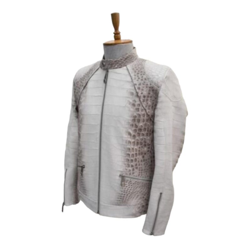 Puede incluir: Chaqueta de cuero blanca con cuello alzado y cierre de cremallera. Los hombros y la parte superior de las mangas presentan un patr&oacute;n texturizado, similar al de un cocodrilo, en color marr&oacute;n claro. La chaqueta tiene dos bolsillos con cremallera y un corte entallado.