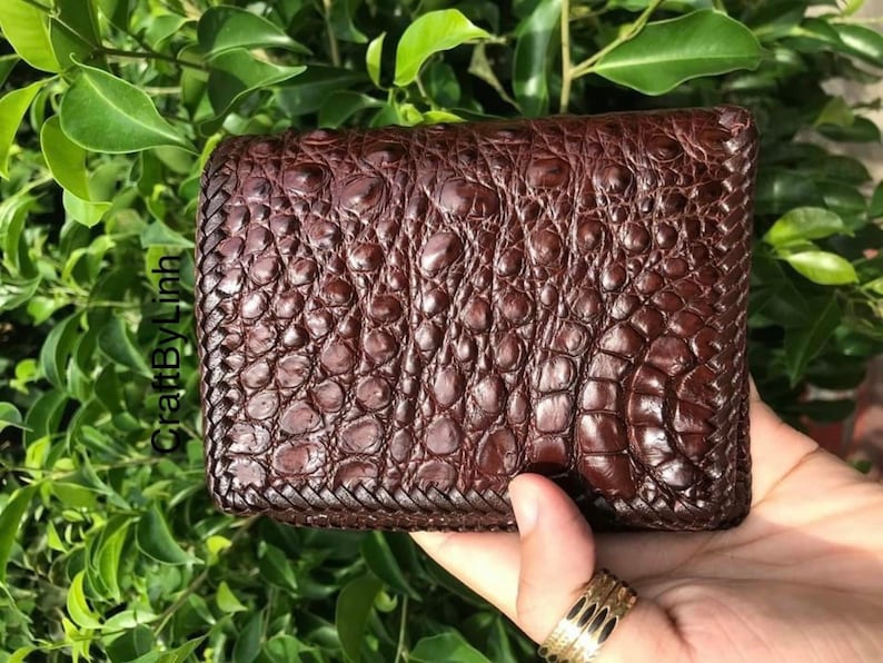 May include: A brown leather wallet with a crocodile skin pattern.