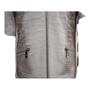 Puede incluir: Chaqueta gris claro con un patr&oacute;n de piel de cocodrilo. La chaqueta tiene una cremallera de largo completo y dos bolsillos con cremallera. Las mangas son cortas. La chaqueta est&aacute; hecha de un material texturizado.