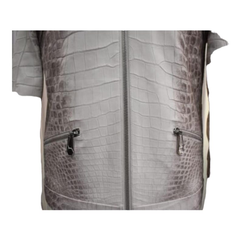 Puede incluir: Chaqueta gris claro con un patr&oacute;n de piel de cocodrilo. La chaqueta tiene una cremallera de largo completo y dos bolsillos con cremallera. Las mangas son cortas. La chaqueta est&aacute; hecha de un material texturizado.