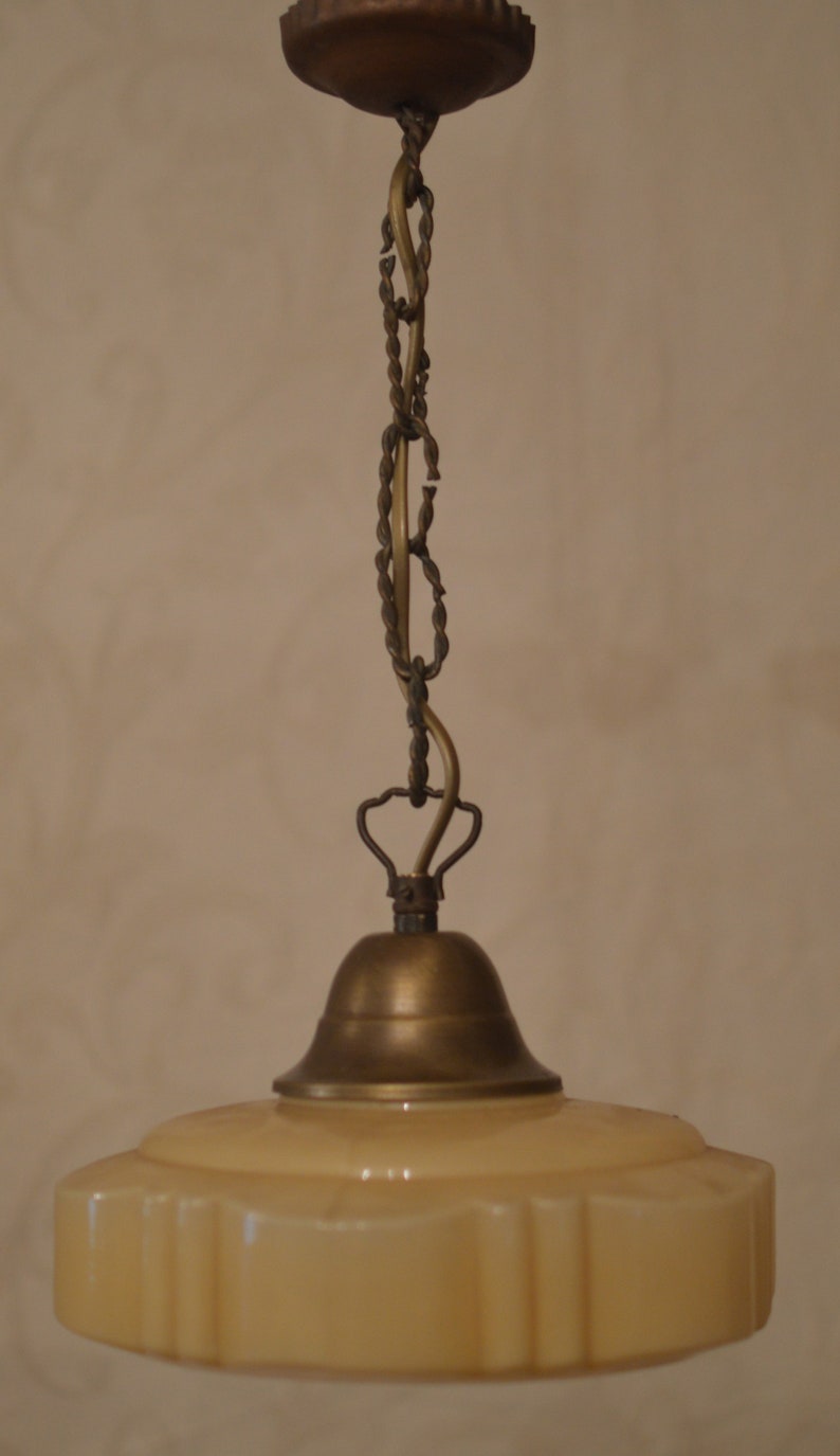 K&ouml;nnte beinhalten: Eine vintage H&auml;ngelampe aus Messing und cremefarbenem Glas mit einer Kette und einem glockenf&ouml;rmigen Oberteil.