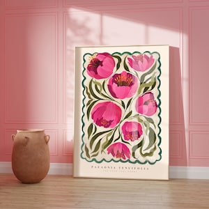 May include: Pink floral poster print featuring Paeonia tenuifolia, The York Print Works. The artwork showcases a cluster of vibrant pink flowers with green foliage on a cream background, framed by a teal border with a scalloped edge.  The poster's dimensions are not specified, but it is displayed in a room setting.