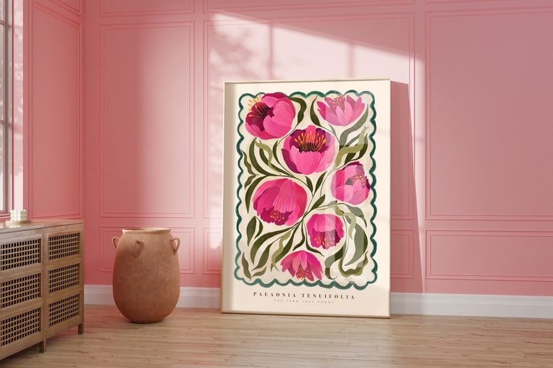 May include: Pink floral poster print featuring Paeonia tenuifolia, The York Print Works. The artwork showcases a cluster of vibrant pink flowers with green foliage on a cream background, framed by a teal border with a scalloped edge.  The poster's dimensions are not specified, but it is displayed in a room setting.