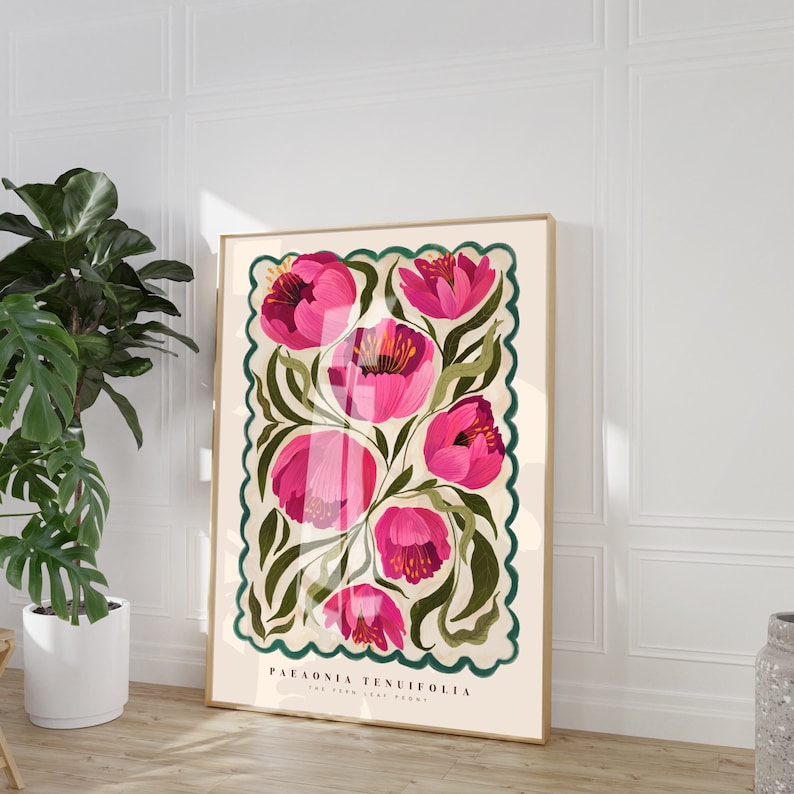 May include: Framed botanical illustration featuring pink Paeonia tenuifolia, also known as the fern leaf peony. The artwork showcases several blossoms in varying shades of pink against a cream background, accented with dark green foliage.  The illustration is enclosed within a scalloped, teal-green border. The botanical name and common name are printed at the bottom. The overall style is reminiscent of vintage botanical prints.