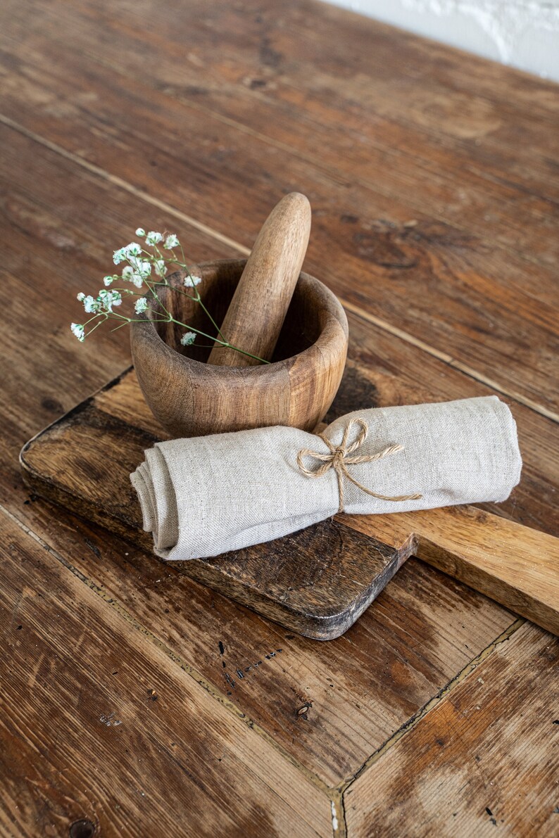 a wooden mortar and mortar bowl on a wooden table