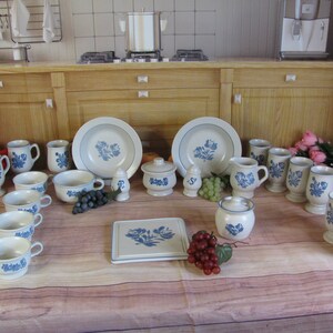 May include: A collection of blue and white patterned ceramic dishes, mugs, and bowls. The set includes two large serving bowls, a sugar bowl, a creamer, a salt and pepper shaker, and several mugs and bowls.