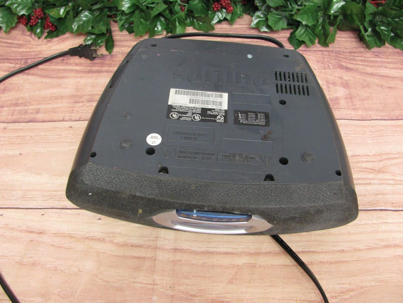 May include: Black DVD player with a silver trim and a power cord. The player has a label on the top that says "Sanyo".