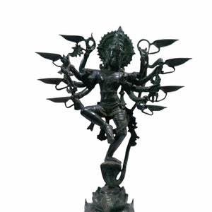 May include: A dark green bronze statue of a Hindu deity with multiple arms, standing on a lotus base. The deity is depicted in a dancing pose, with a crown and jewelry.
