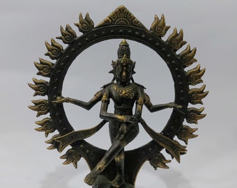 May include: A black and gold metal statue of a Hindu deity, Shiva Nataraja, in a dancing pose. The statue is surrounded by a circular halo of flames and stands on a square base. The base has the text "Made in Indonesia" on it.