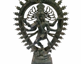 May include: A green bronze statue of the Hindu deity Shiva in the Nataraja pose, dancing on a demon. The statue is surrounded by a circular halo with intricate carvings.