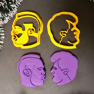 Puede incluir: Dos juegos de cortadores de galletas, uno amarillo y otro morado, con forma de perfiles de dos caras.