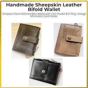 May include: Three bifold wallets made of sheepskin leather in black, dark brown, and light brown. Each wallet features a snap button closure, a side zipper, and a metal D-ring. The text reads: Handmade Sheepskin Leather Bifold Wallet.