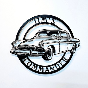 Könnte beinhalten: Schwarze und weiße Wandkunst aus Metall mit einem Oldtimer und dem Text "Jim's Commander" in einem Kreis darum.