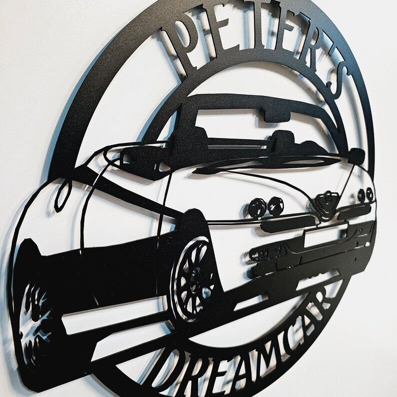 May include: Black metal wall art featuring a silhouette of a convertible car with the words "PIETERS DREAMCAR" around the perimeter.