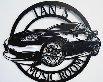 May include: Black metal sign with a silhouette of a sports car and the text "Ian's Music Room".