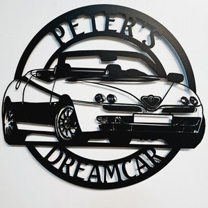 May include: Black and white metal wall art featuring a silhouette of a convertible car with the words "Peter's Dreamcar" around the car.