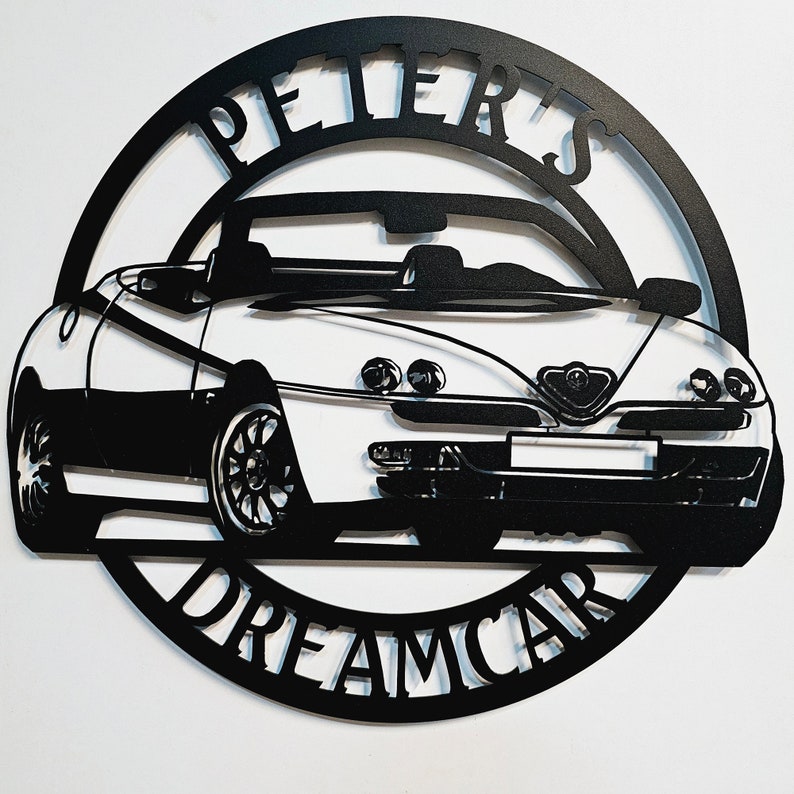 May include: Black and white metal wall art featuring a silhouette of a convertible car with the words "Peter's Dreamcar" around the car.