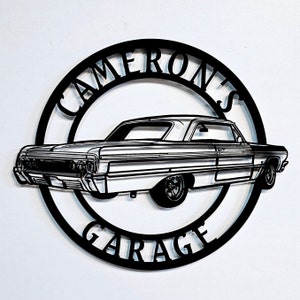 Könnte beinhalten: Schwarzes Metallschild mit einem runden Design. Das Schild zeigt den Text "Cameron's Garage" und eine Silhouette eines Oldtimers.