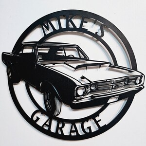 May include: Black metal sign with a silhouette of a classic car and the text "Mike's Garage" in a circular design.