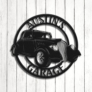 May include: Black metal sign with a vintage car silhouette and the text "Austin's Garage" in a circle.