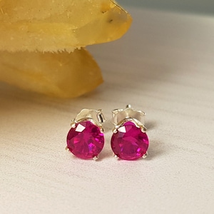 Może przedstawiać: Para srebrnych kolczyków z okrągłymi, jasnoróżowymi kamieniami.