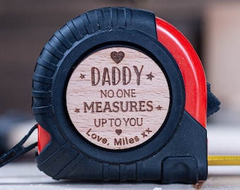May include: A red and black tape measure with a wooden heart-shaped tag that says "Daddy No One Measures Up To You Love, Miles xx".