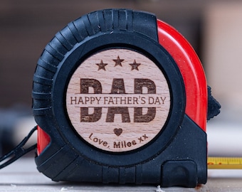 May include: A red and black tape measure with a wooden insert that says "Happy Father's Day Dad" with three stars and a heart. The text "Love, Miles xx" is also on the insert.