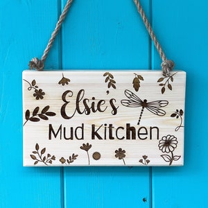Mud Kitchen Sign With Dragon Fly and Floral Design Frame Around the Name and Mud Kitchen Text