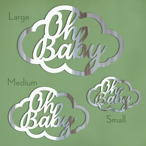 Może przedstawiać: Trzy srebrne, lustrzane kształty chmur z napisem "Oh Baby" napisanym kursywą. Chmury są w r&oacute;żnych rozmiarach, oznaczone jako "Large", "Medium" i "Small".