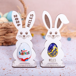 Personalised Easter Egg Holder made from 3mm wood or 4mm Beech Veneered Wood, Egg holder has a cut out to fit Kinder Surprise Egg and Cadbury Egg Creme, Name engraved in front of the wooden Easter bunny standing with a base.