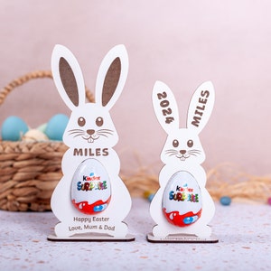 Personalised Easter Egg Holder made from 3mm wood or 4mm Beech Veneered Wood, Egg holder has a cut out to fit Kinder Surprise Egg and Cadbury Egg Creme, Name engraved in front of the wooden Easter bunny standing with a base.