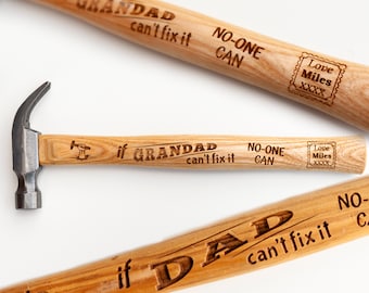 Puede incluir: Dos martillos de madera con texto grabado. Los martillos tienen cabezas de metal negro y mangos de madera. El texto en los martillos dice "Si GRANDAD no puede arreglarlo, NADIE PUEDE" y "Si DAD no puede arreglarlo, NADIE PUEDE".