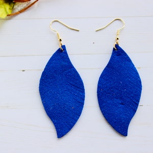 May include: A pair of blue leather earrings shaped like leaves. The earrings have gold hooks.