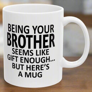 May include: White ceramic mug with black text that reads "Being your brother seems like gift enough... but here's a mug".