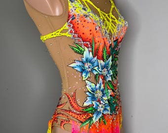 Può includere: Un body color carne con un designo floreale giallo, arancione e rosa. Il body ha un corpetto in rete con un motivo a croce giallo.