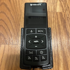 May include: A black remote control with a digital display and buttons for controlling a trolling motor. The remote is labeled "Minn Kota" and has buttons for anchor, speed, and direction.