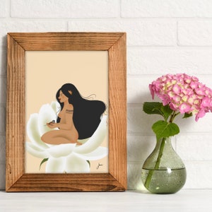 May include: A framed illustration of a woman with long black hair sitting on a large white flower. She is holding a small bird in her hand. The background is a light peach color.