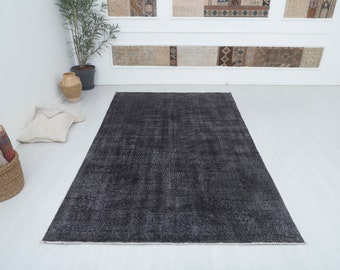 May include: A dark gray distressed rug with a subtle pattern. The rug is made of a soft, durable material and is perfect for adding a touch of style to any room.
